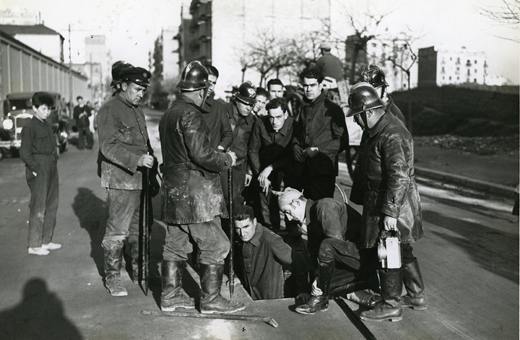 Bombers i guàrdies d’assalt surten d’una claveguera que comunica amb La Model i per la qual es van fugar 58 presos, l’any 1933.